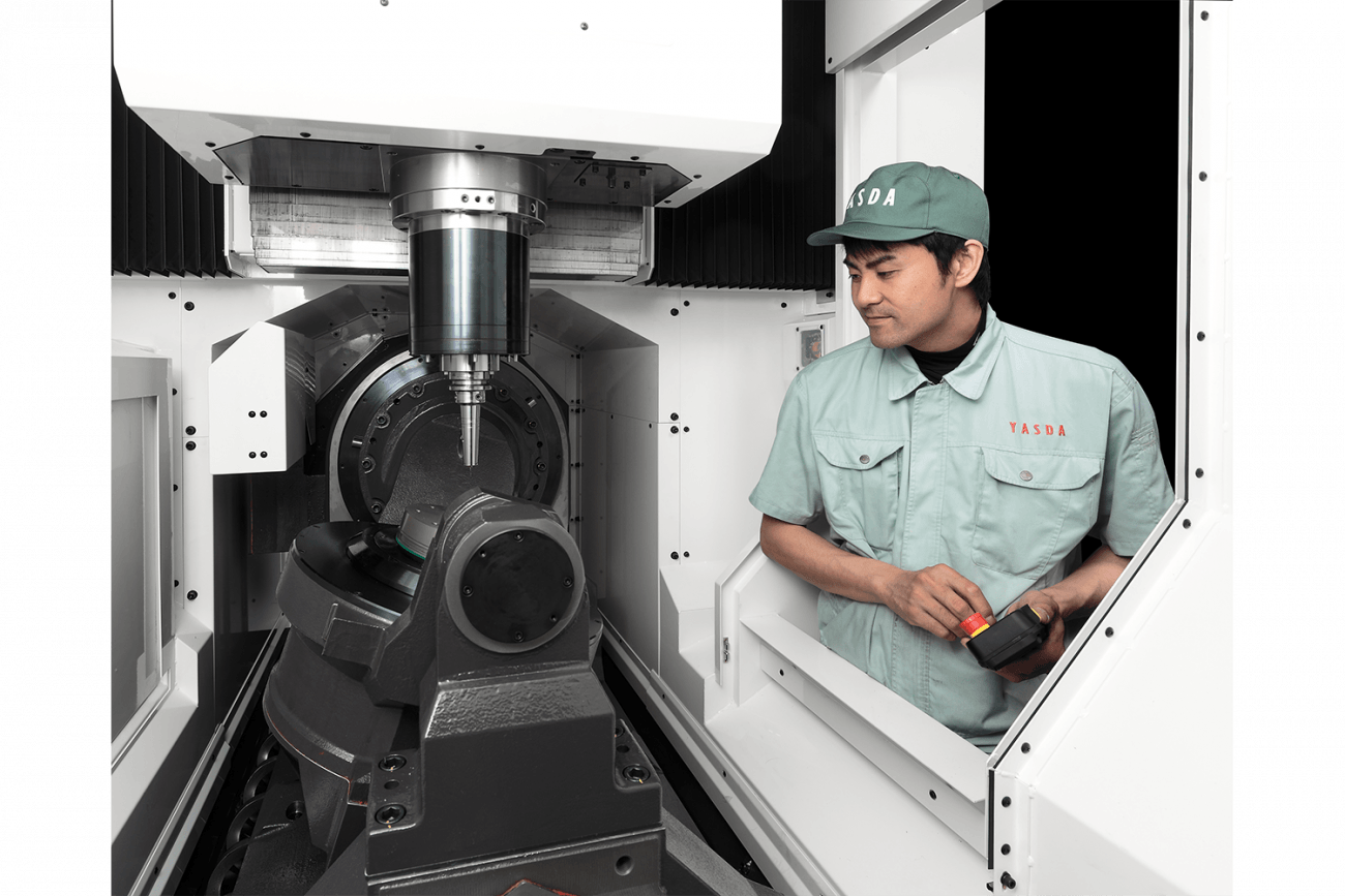 engineer standing near the Yasda PX30i 5-axis vertical machining center sold by Methods Machine Tools