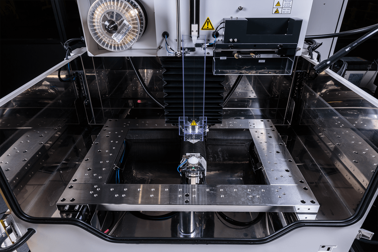 the inside of the FANUC RoboCut C600iC Wire EDM machine as it threads a part